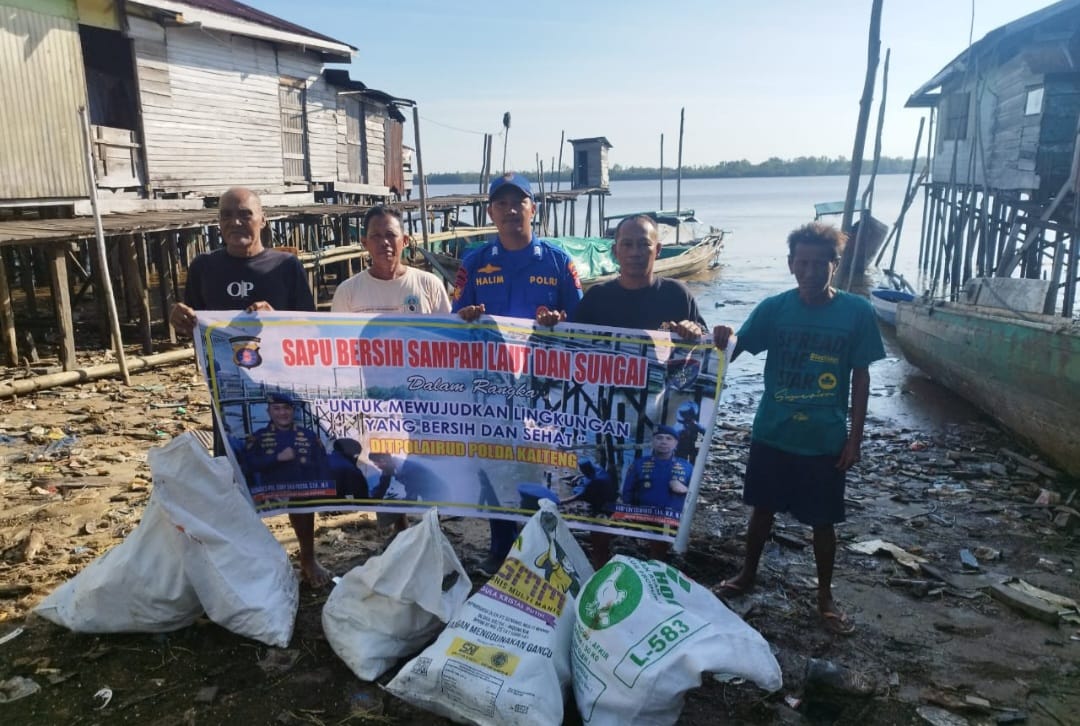 Personel Ditpolairud Polda Kalteng Mengajak Masyarakat Pegatan Bersihkan Sampah Di Persisir Pegatan Hilir