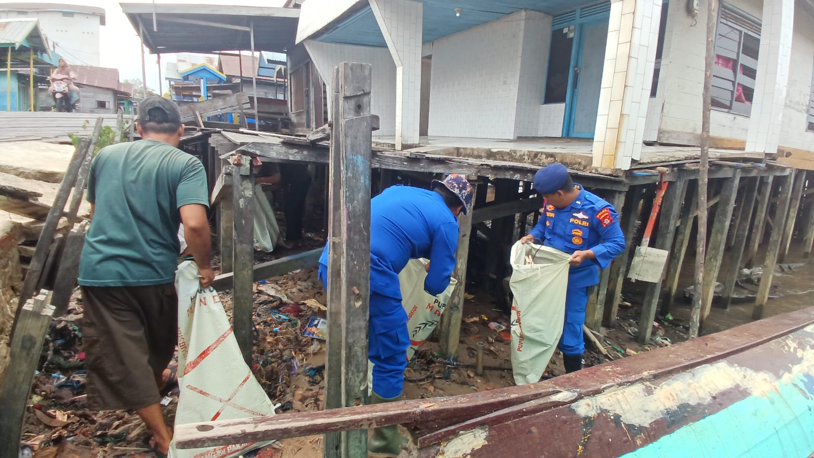 Personel Ditpolairud Polda Kalteng Mengajak Masyarakat Pegatan Bersihkan Sampah Di Persisir Pegatan Hilir